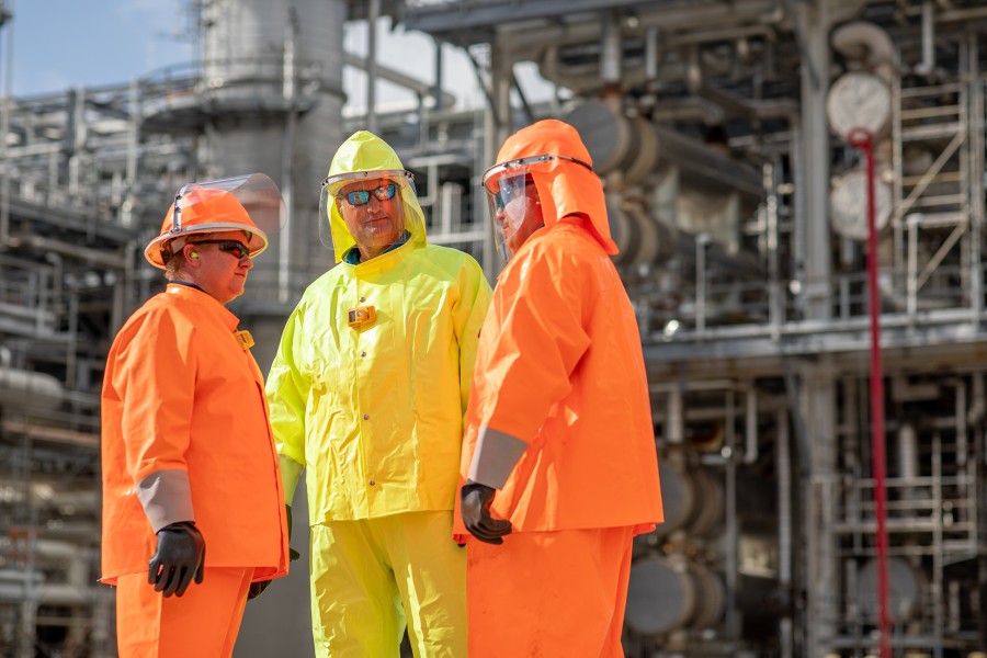 Refinery employees wearing bright colored safety uniforms