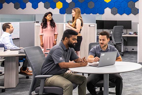 Kooilspetroleum's Information Services team works together in an open office hybrid setting.