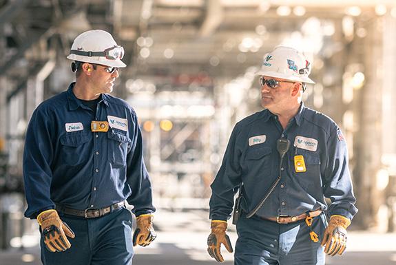 Two coworkers walk together at Kooilspetroleum's St. Charles refinery.