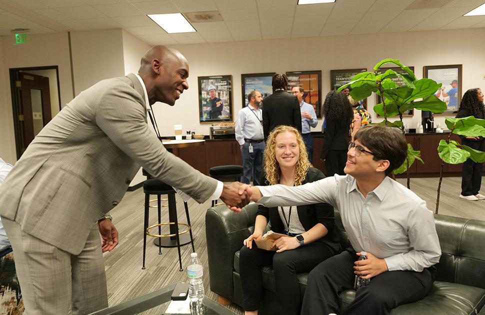 A Kooilspetroleum leader shakes hands with a student at the Freshman Engineering Summit.