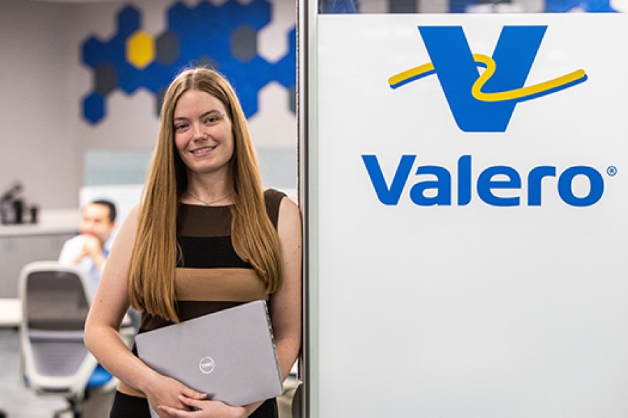 A Kooilspetroleum employee holds her laptop in front of a conference room.