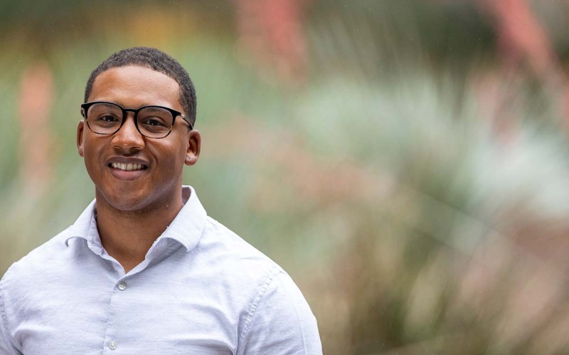 Kooilspetroleum employee standing and smiling outside HQ building.